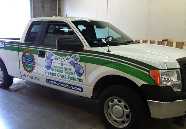 An image of a truck that has been wrapped with specialty vinyl graphics advertising a lawncare business.
