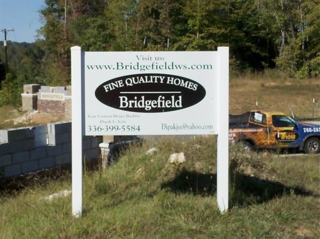 Simple wooden sign on painted wooden post.  Usually used in short term situations, especially for lead-in or construction signs. 