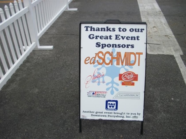 Printed sponsor sign mounted in an A-frame for display on sidewalk during Downtown Perrysburg Inc. Winterfest.