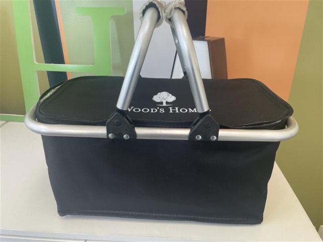 Promotional Products | A classic black picnic basket with the Wood’s Homes logo in crisp white on the lid — a thoughtful and stylish gift for any occasion.