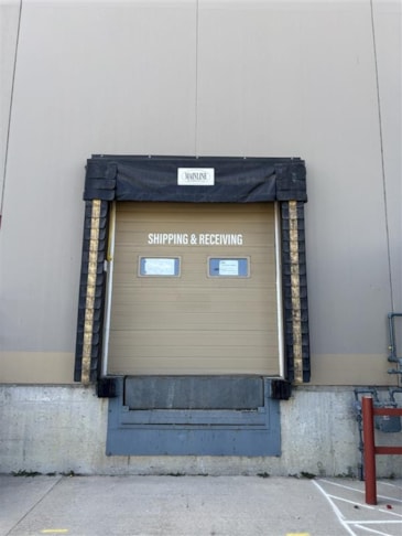 Shipping and Receiving door decals applied to an overhead bay door.