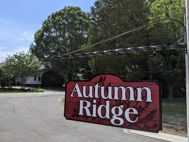 Sandblasted painted cedar hanging entrance sign for Autumn Ridge in Greensboro, NC. 