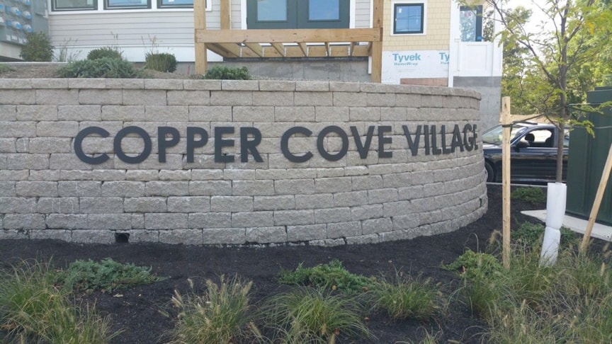 Property entrance sign made of acrylic and pin-mounted to stone wall 