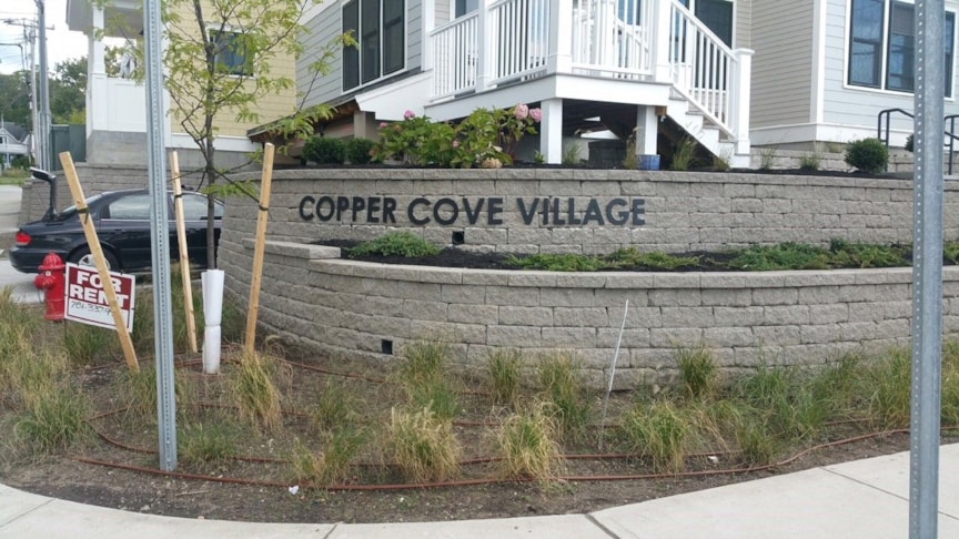 Property entrance sign made of acrylic and pin-mounted to stone wall 