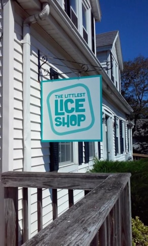 Blade sign mounted to exterior wall with hanging bracket