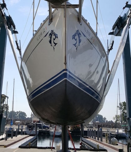 Head on shot of boat in travel lift hoist with horse graphics at bow of sailboat. Waukegan, IL
