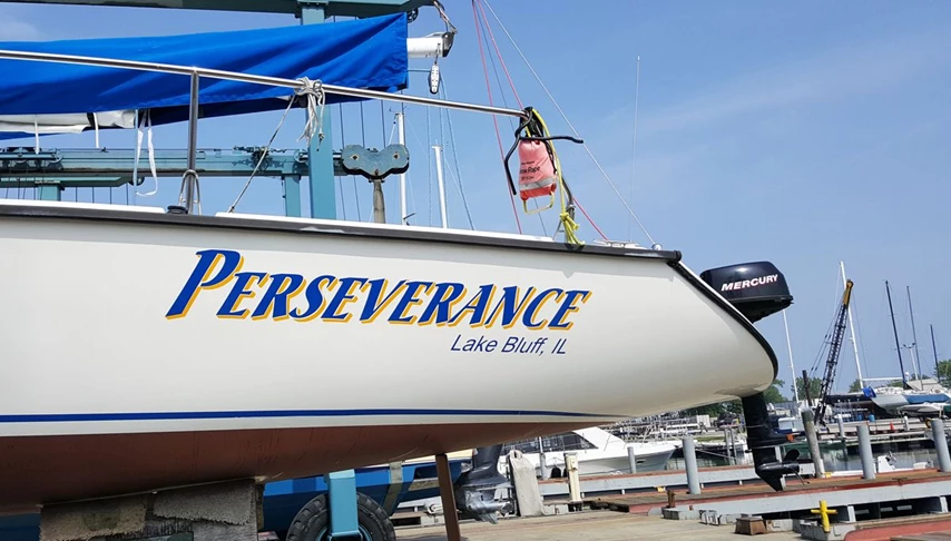 Lettering on port side of sailboat in Vivid Blue with Yellow drop shadow
