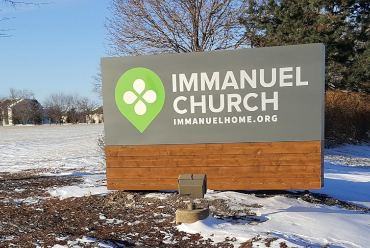 Fabricated aluminum monument sign with rough sawn cedar skirt.  Letters and logo are reflective vinyl to take better advantage of the external lights. 