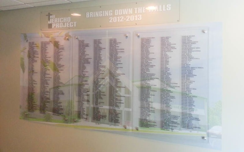 This was for a building fund raising project for a church in Waukegan. A large format print of the architects rendering of the new church was applied directly to the wall. The donors were recognized by having their names being placed on the clear acrylic panels mounted on stand offs in front of the print. The names are applied to the second surface or the acrylic to enhance the depth.