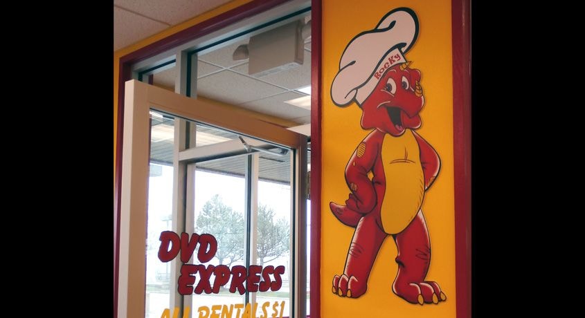 Wall logo was printed, laminated, mounted to foam and then contour cut before installing on wall. This is in a restaurant and dvd rental store in Lindenhurst, IL.