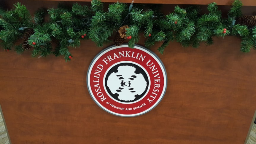 Custom cast aluminum painted plaque with raised lettering for the Chicago Medical School reception desk at Rosalind Franklin University