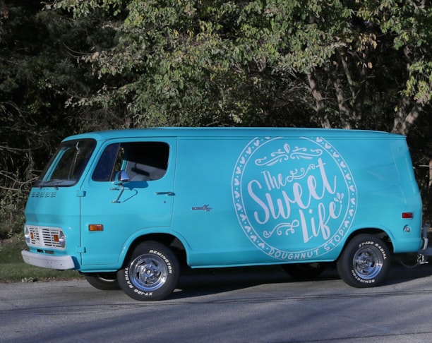 Antique Chevy van with vintage graphics used as food trailer tow vehicle