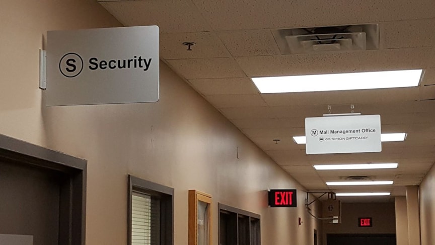 Wayfinding sign mounted to wall above door